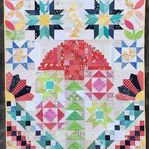May include: A colorful quilt with a variety of geometric patterns, including stars, squares, and triangles. The quilt is made with a variety of fabrics in shades of red, green, blue, yellow, and white. The quilt is quilted with a white thread.