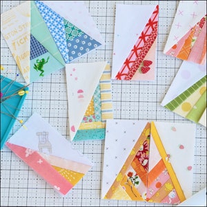 Pode incluir: Uma coleção de nove quadrados de tecido com padrões e cores diferentes, incluindo rosa, amarelo, azul, verde e vermelho. Os quadrados estão dispostos sobre uma superfície branca quadriculada. Alguns dos quadrados têm um pequeno desenho no centro, como um sapo ou um morango.