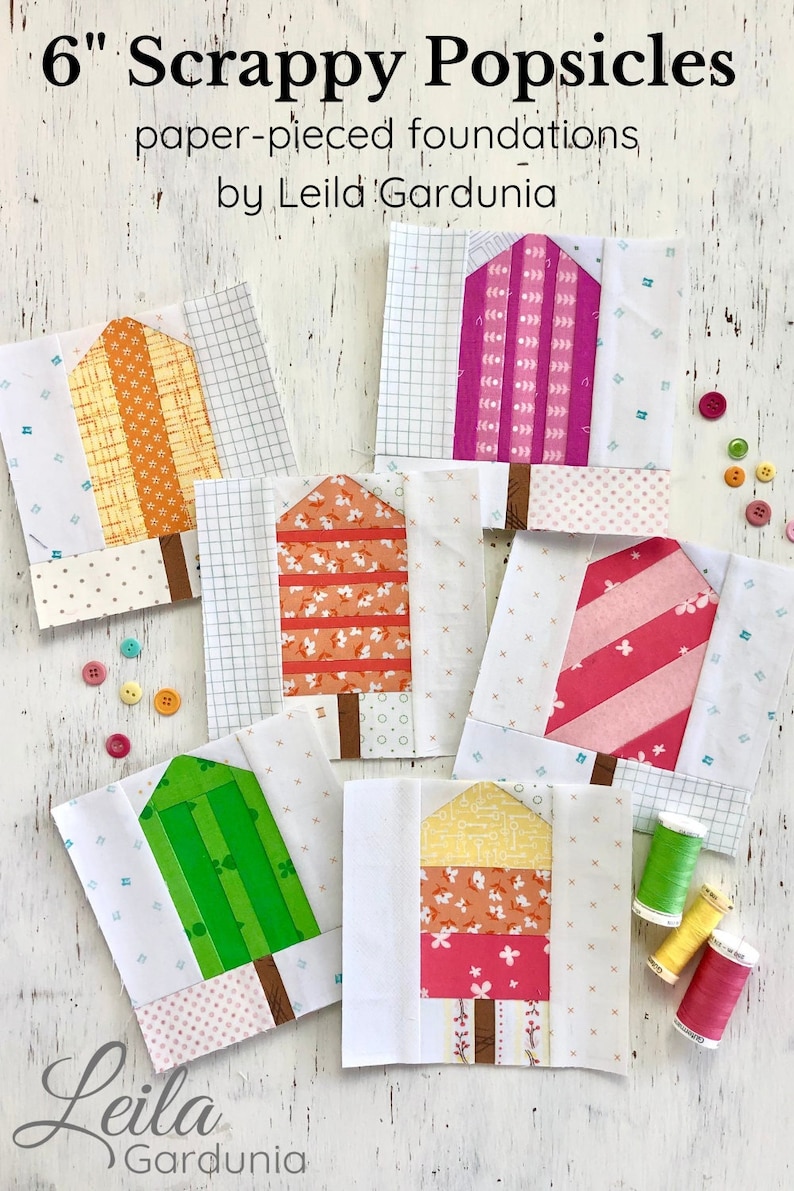 Pu&ograve; includere: Sei blocchi di patchwork a forma di ghiacciolo da 15 cm, realizzati con fondazioni di carta. I blocchi presentano una variet&agrave; di tessuti colorati con diversi motivi, tra cui strisce, pois e stampe floreali. I blocchi sono disposti su una superficie di legno bianco con bottoni e bobine di filo.