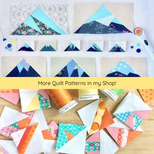 Pu&ograve; includere: Una collezione di quadrati di tessuto colorati con motivi geometrici, tra cui triangoli, rombi e disegni floreali. I quadrati sono disposti su una superficie di legno con bobine di filo. Il testo "More Quilt Patterns in my Shop!" &egrave; visibile nella parte superiore dell'immagine.