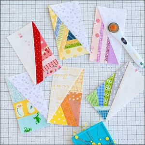 May include: A collection of colorful fabric pieces arranged on a cutting mat. The pieces are rectangular with a triangular section, showcasing various patterns like floral, polka dots, and stripes. A rotary cutter and pins are also visible.