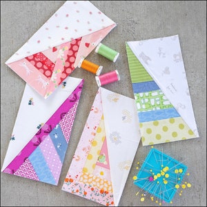 Pu&ograve; includere: Cinque quadrati di tessuto con diversi motivi e colori, tra cui rosa, blu, giallo, verde e bianco. I quadrati sono disposti in diagonale, con il quadrato superiore che si sovrappone agli altri. I quadrati sono tutti in tessuto di cotone e presentano una variet&agrave; di motivi, tra cui pois, strisce e motivi floreali. I quadrati sono tutti cuciti insieme con un filo bianco. I quadrati misurano circa 30 cm per 30 cm.