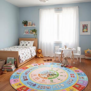 May include: A large, round, colorful educational area rug featuring a central clock face, months of the year, and an outer border with alphabet letters, corresponding illustrations, and words like Pizza, Night, Milk, and Lion on a wooden floor.