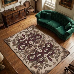 Può includere: Un tappeto rettangolare con sfondo beige, con un disegno di serpente bordeaux intrecciato con motivi floreali e fogliari. Il tappeto è posato su un pavimento in legno, con un divano verde e mobili antichi sullo sfondo.
