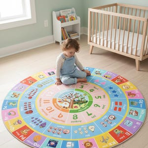 May include: A round, multi-colored educational area rug featuring an alphabet border with illustrations, a central clock face, months of the year, and seasonal tree imagery. The rug displays numbers, shapes, and various colorful icons for learning.