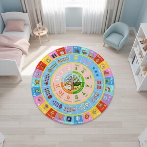 May include: A circular educational area rug featuring a colorful design with the alphabet, numbers one through twelve, months of the year, and seasonal illustrations. The rug displays letters from A to Z, counting graphics, and a central tree motif.