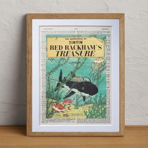 May include: Framed print of a vintage comic book cover, "The Adventures of Tintin: Red Rackham's Treasure." The artwork features a black and white shark underwater, with red and yellow fish and green seaweed.