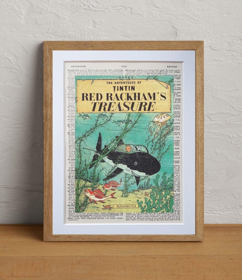 May include: Framed print of a vintage comic book cover, "The Adventures of Tintin: Red Rackham's Treasure." The artwork features a black and white shark underwater, with red and yellow fish and green seaweed.