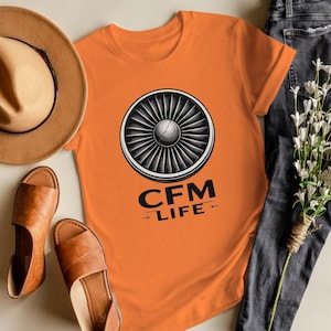 May include: A white ceramic mug with a black handle and the text "But First, Coffee" in a bold, black font. The mug is set against a neutral background, highlighting its simple design.