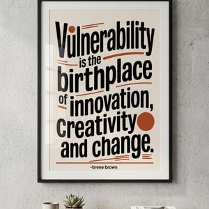 May include: Framed art print with the quote "Vulnerability is the birthplace of innovation, creativity, and change" by Brene Brown. The text is in black with rust-colored accents on a cream background.