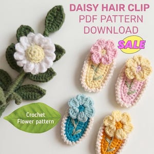 May include: A selection of crocheted daisy hair clips in shades of white, pink, yellow, and blue. The image also shows a crocheted daisy flower and leaf, with text reading "Easy Crochet Daisy Hair Clip PDF Pattern Download" and a "Sale" label.