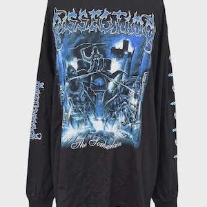May include: A black long-sleeve t-shirt featuring a blue graphic print of a horse-drawn carriage with a driver in a top hat. The text DISSECTION appears at the top in a stylized font, and the text The Somberlain is printed below the carriage.