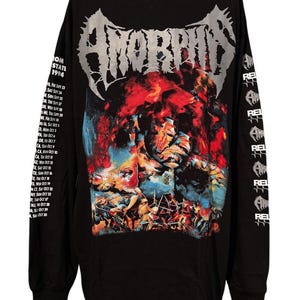 May include: A black long-sleeve t-shirt featuring the word AMORPHIS in large silver lettering at the top. The center graphic depicts a colorful battle scene with red and blue tones. The left sleeve lists tour dates and the right sleeve repeats the logo.