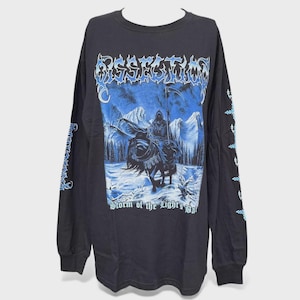 Peut inclure: T-shirt noir à manches longues avec un motif d'une figure encapuchonnée à cheval avec une faux, sur fond de montagnes enneigées. Le texte "Storm of the Light's Bane" est en dessous. Les manches ont des accents bleus.