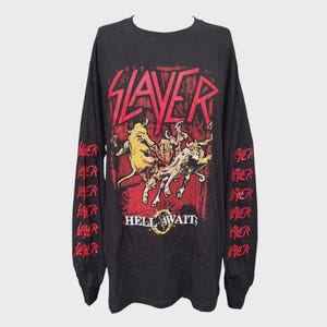 May include: Black long-sleeve t-shirt with a red and yellow graphic. The graphic features the band name "SLAYER" in red, with a red background and a yellow illustration of figures. The sleeves have the word "SLAYER" printed in red.