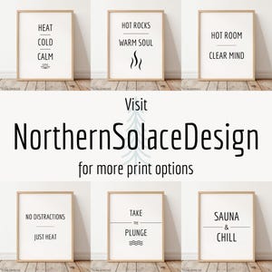 May include: A collection of framed art prints with minimalist designs. Each print features black text on a white background, with phrases like "Heat, Cold, Calm" and "Hot Rocks, Warm Soul." The prints are displayed on a wooden floor.