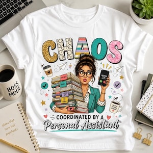 May include: A white t-shirt featuring a graphic of a person holding a large stack of files, a smartphone, and the text "CHAOS COORDINATED BY A PERSONAL ASSISTANT". The design includes colorful stars, hearts, and coffee cups in a cartoon illustration style.