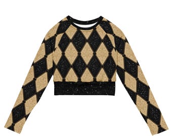 May include: A long-sleeve crop top featuring a repeating diamond harlequin pattern in black and tan. The black diamonds have a textured, glittery appearance, while the tan diamonds have a subtle, mottled texture. A solid black band finishes the hem.
