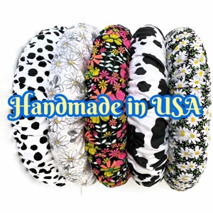 May include: A collection of fabric-covered items with various patterns, including black and white polka dots, daisies, a floral design, cow print, and more daisies. The text "Handmade in USA" is displayed in a blue and yellow font.