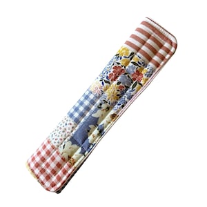 May include: A patchwork pot holder with a red, white, and blue gingham pattern, a floral pattern, and a blue and white striped pattern.