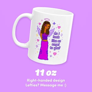 May include: White 11 oz ceramic mug featuring a pixelated illustration of a woman with angel wings and the text "do i look like an angel to you?". The design includes hearts, stars, and a halo. The mug has a right-handed design.
