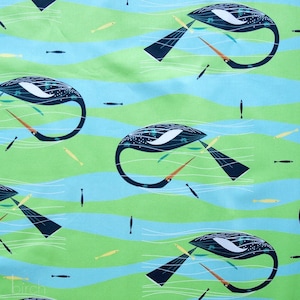 May include: A green and blue fabric with a repeating pattern of stylized black and white birds with long beaks. The birds are swimming in a wavy pattern, and there are small yellow fish scattered throughout the design.
