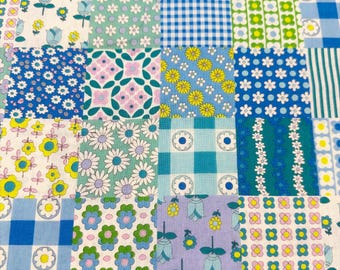 May include: A patchwork quilt featuring a variety of floral and geometric patterns in shades of blue, green, yellow, and purple. The quilt is composed of numerous fabric squares, each with a unique design, creating a vibrant and colorful textile.