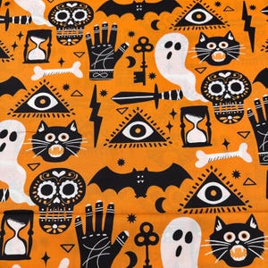 May include: Orange Halloween-themed fabric with repeating patterns of black bats, cats, skulls, ghosts, hourglasses, hands, keys, swords, and triangles with eyes. The design is a mix of spooky and mystical elements.