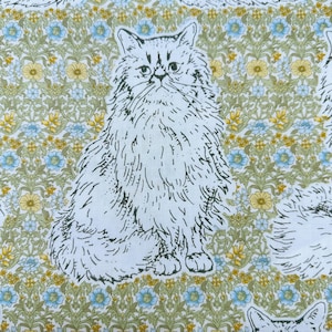 May include: A fabric print featuring a repeating pattern of long-haired cats in black line art. The background consists of a dense botanical design with yellow flowers, light blue blossoms, and green foliage on a white base fabric.