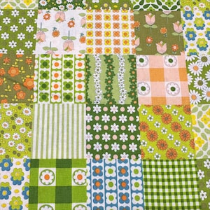 May include: A patchwork quilt featuring a mix of floral and geometric designs in green, orange, white, and blue. The quilt is made up of many fabric squares, each with a unique pattern, creating a vibrant and colourful textile.