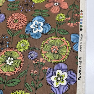 May include: Brown floral fabric with a repeating pattern of stylized flowers in shades of orange, blue, green, and purple. The fabric has a vintage aesthetic, with the text "MADE IN JAPAN" visible.