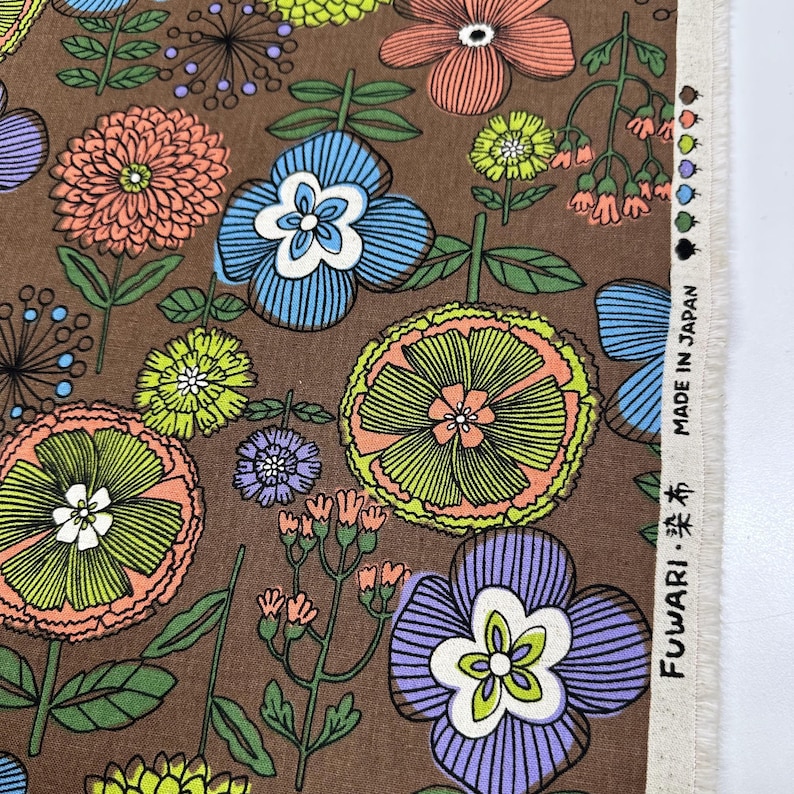 May include: Brown floral fabric with a repeating pattern of stylized flowers in shades of orange, blue, green, and purple. The fabric has a vintage aesthetic, with the text "MADE IN JAPAN" visible.
