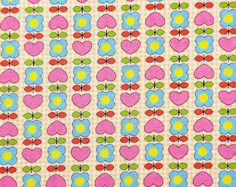 May include: A repeating pattern of pink hearts and blue flowers with yellow centers on a beige checkered background. The design also includes small green and red leaf-like accents, creating a cheerful, vintage-inspired fabric.