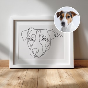 Op de afbeelding: Een witte fotolijst met een zwarte doorlopende lijntekening van een hondengezicht. Een cirkelvormige inzet in de rechterbovenhoek toont een kleurenfoto van dezelfde hond met bruine, zwarte en witte vachtmarkeringen.