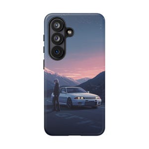 以下が含まれることがあります： 夕焼けの山道を走る白いスポーツカーの風景イラストが描かれた、ネイビーブルーの携帯電話ケース。ケースにはトリプルレンズカメラ用の切り抜きと濃い青色の縁があります。