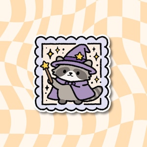 May include: A square sticker with a scalloped edge featuring a cartoon raccoon wearing a purple wizard hat and cape. The raccoon holds a brown wand with a yellow star tip. The background is cream-colored with small yellow stars and black outlines.