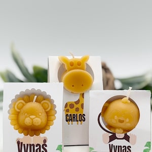 May include: Three animal-shaped candles: a lion, a giraffe, and a monkey. The lion candle is in a white box with the name "Vynas". The giraffe candle has the name "Carlos". The monkey candle is in a white box with the name "Vynas".