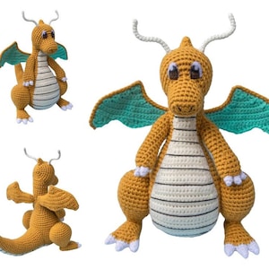 May include: Crocheted dragon toy in shades of gold, white, and teal. The dragon has large wings, a striped belly, and white accents on its feet and horns. The toy is handmade and appears soft and cuddly.