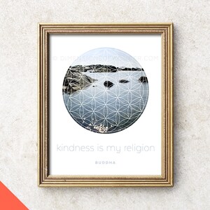 May include: A framed print with a white background and a circle in the centre. The circle contains a photo of a body of water with rocks and a geometric pattern overlayed. The text "kindness is my religion" is below the circle, with the word "BUDDHA" below that.