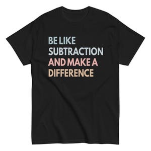 Könnte beinhalten: Schwarzes T-Shirt mit dem Text "BE LIKE SUBTRACTION AND MAKE A DIFFERENCE" in Hellblau, Weiß, Rosa und Beige. Das T-Shirt hat einen Rundhalsausschnitt und kurze Ärmel.