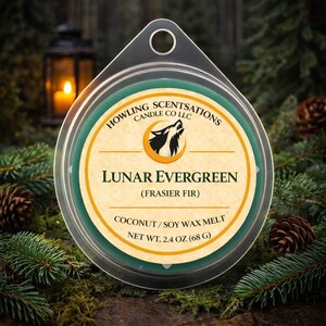 Puede incluir: Un recipiente redondo de cera perfumada con el texto "Lunar Evergreen" y "Frasier Fir". El recipiente está rodeado de agujas de pino y piñas. El peso neto es de 68 g. La marca "Howling Scentsations" también es visible.