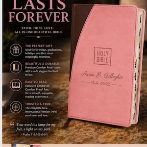 May include: A pink Holy Bible with the text "Holy Bible" and the name "Aaron B. Gallagher" on the cover. The text "A GIFT THAT LASTS FOREVER" is at the top. The Bible is a New International Version (NIV).