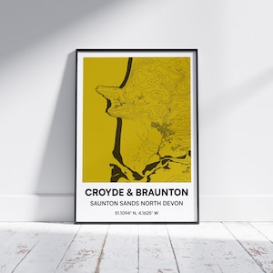 May include: Framed map print of Croyde & Braunton, Saunton Sands, North Devon, in a black frame. The map features a yellow background with black topographical lines and text. Coordinates are included.