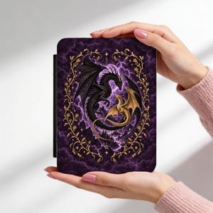 May include: A rectangular e-reader case featuring a dark purple background with swirling clouds and lightning. A large black dragon and a smaller gold dragon are intertwined in the center, surrounded by a decorative gold vine frame with small flowers.