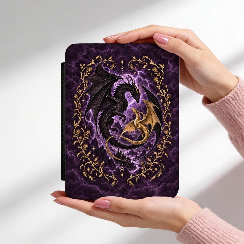 May include: A rectangular e-reader case featuring a dark purple background with swirling clouds and lightning. A large black dragon and a smaller gold dragon are intertwined in the center, surrounded by a decorative gold vine frame with small flowers.