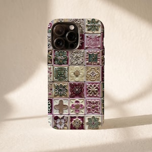 Op de afbeelding: Een smartphonehoesje met een rasterpatroon van vierkante tegels. Elke tegel toont een uniek reliëf bloem- of geometrisch ontwerp in tinten crème, saliegroen, oudroze en bordeauxrood, wat zorgt voor een gestructureerde mozaïeklook.