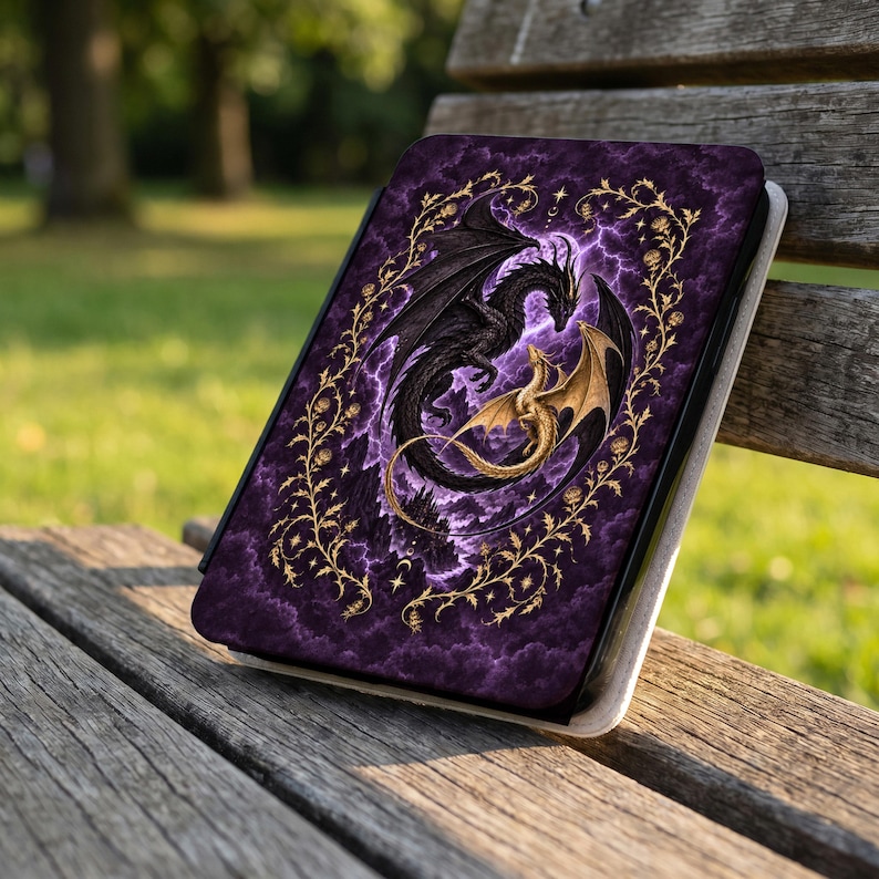 May include: A rectangular e-reader case featuring a dark purple, cloudy background with a large black dragon and a smaller gold dragon intertwined. The design is framed by a golden vine pattern with small flowers, stars, and crescent moon accents.