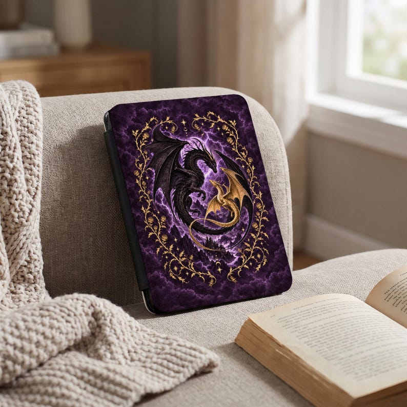 May include: A rectangular e-reader case featuring a dark purple cloudy background with lightning bolts. A large black dragon and a smaller gold dragon are intertwined in the center, surrounded by a decorative gold vine border with small leaves.
