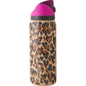 Puede incluir: Una botella de agua Owala de acero inoxidable con tapa rosa y cuerpo beige con un estampado de leopardo marrón y negro. La botella tiene un asa negra y la marca "owala" está impresa en la botella.