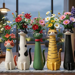 Könnte beinhalten: Fünf dekorative Vasen in Katzenform, jede mit einer anderen Farbe und Gestaltung, gefüllt mit bunten Blumen. Die Katzen haben unterschiedliche Gesichtsausdrücke und Details, wie Streifen, Flecken und Accessoires. Die Blumen verleihen der Präsentation eine lebendige Note.